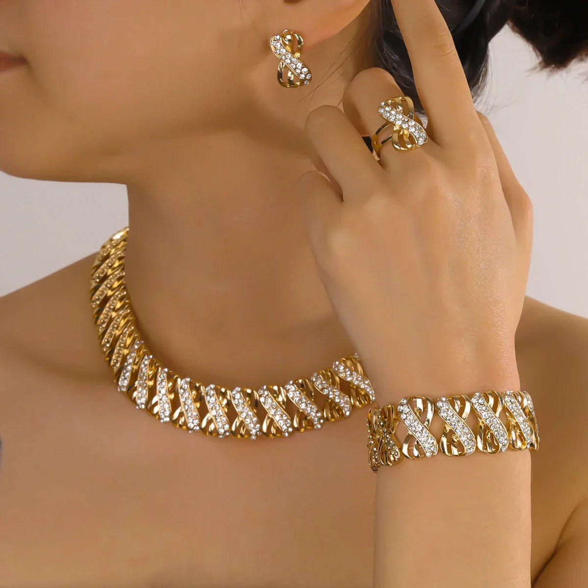Gold-tone geometric jewelry set with necklace, earrings, ring, and bracelet